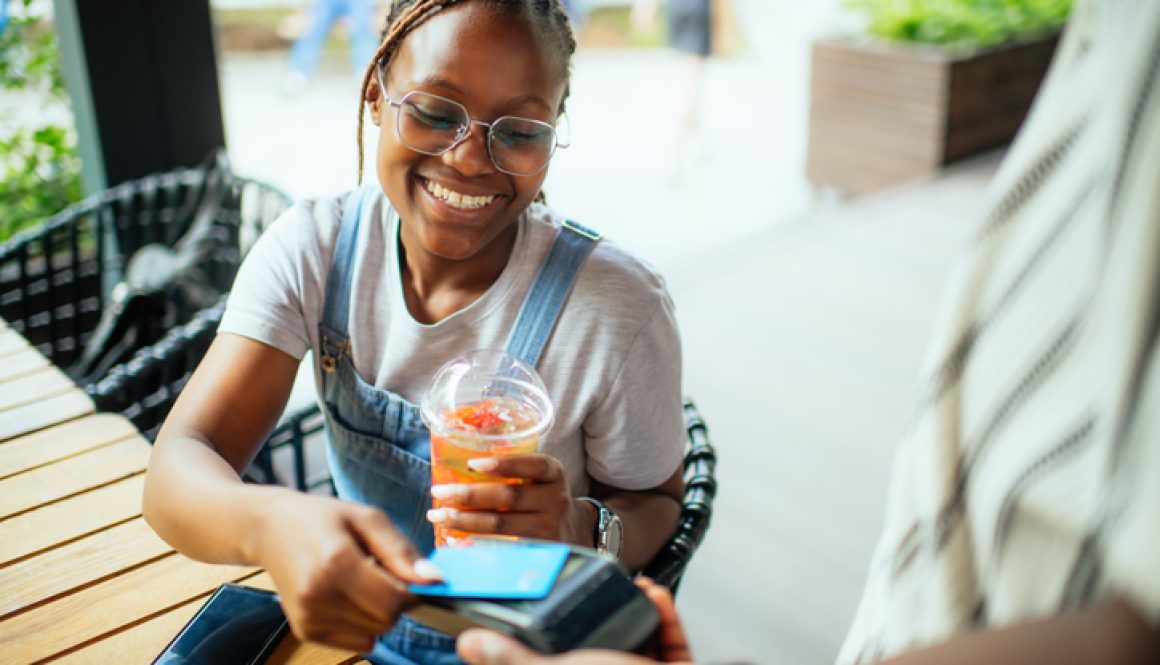 Young woman paying with credit card in a cafe