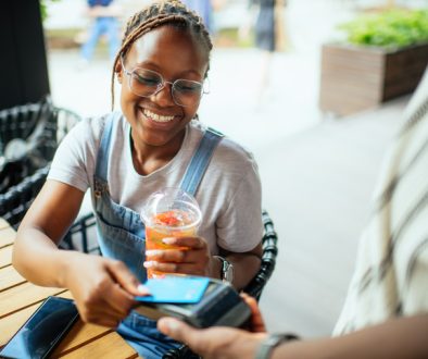 Young woman paying with credit card in a cafe