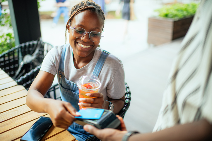 Young woman paying with credit card in a cafe